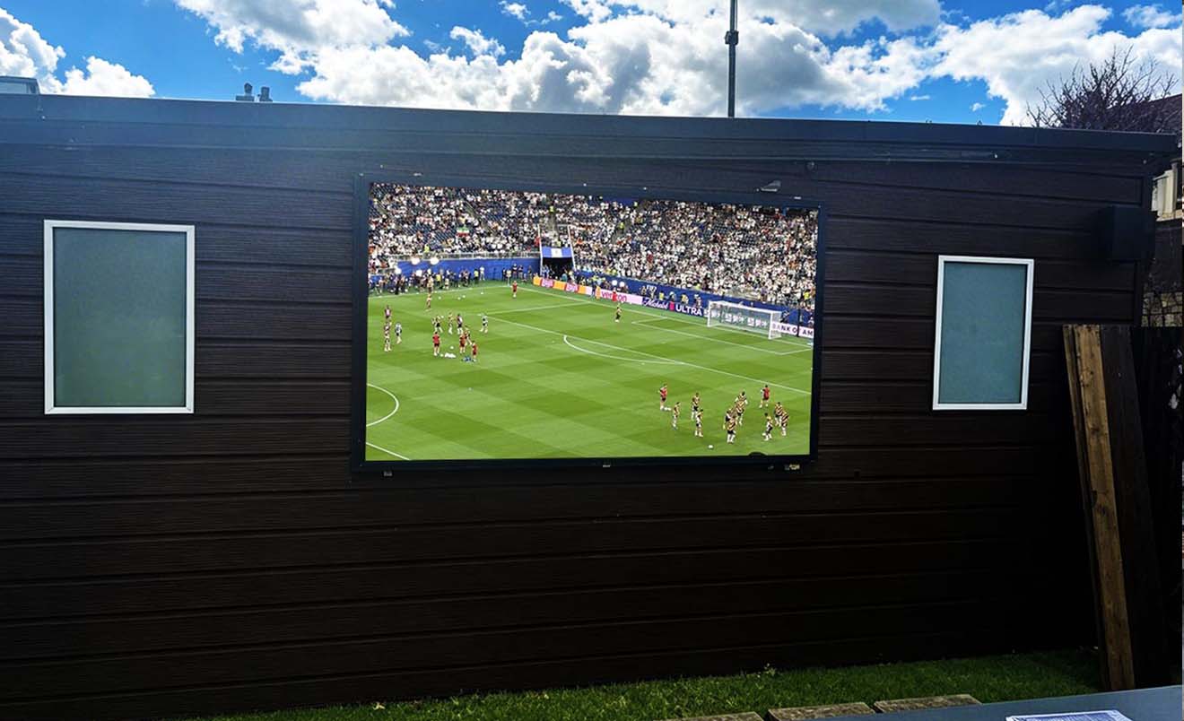 Ultra-slim wall-mounted outdoor LCD digital signage installed in European commercial courtyard for DOOH advertising and public information display network